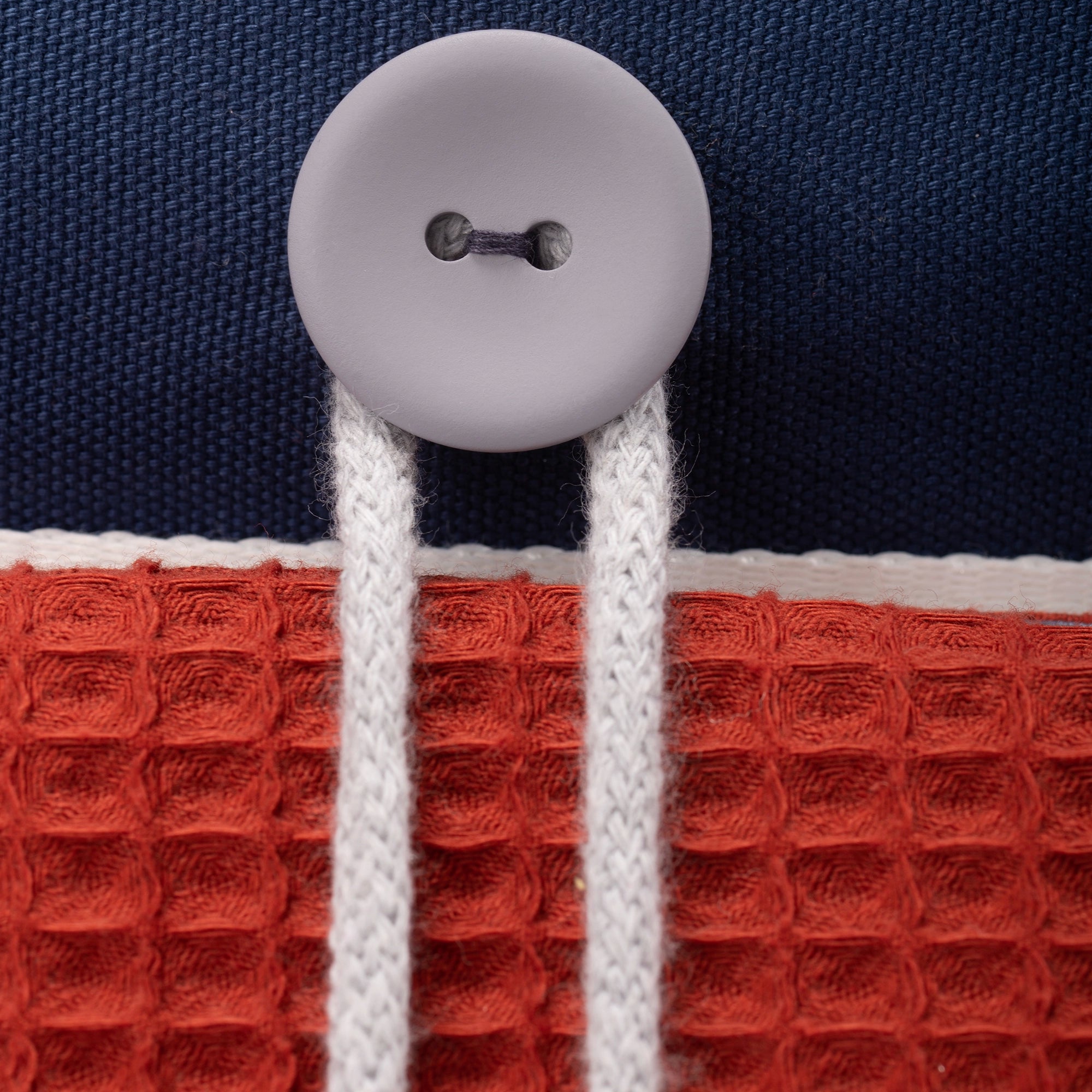 Fundertable Befestigungsdetail mit Knopf und Kordel auf strukturierter Waffelrückseite