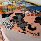 Close-up of multiple fabric panels with playful illustrations including dog, food and market scenes in bright colors