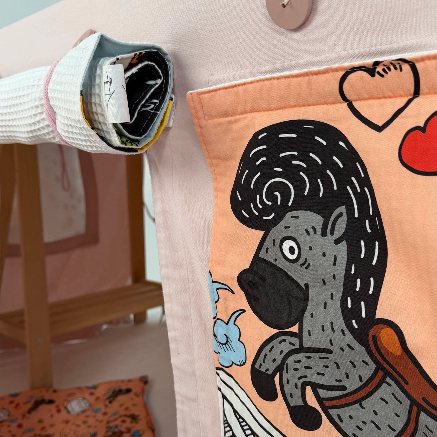 Close-up of fabric panel with a horse illustration attached to a table tent, with a rolled-up flap attached on the side