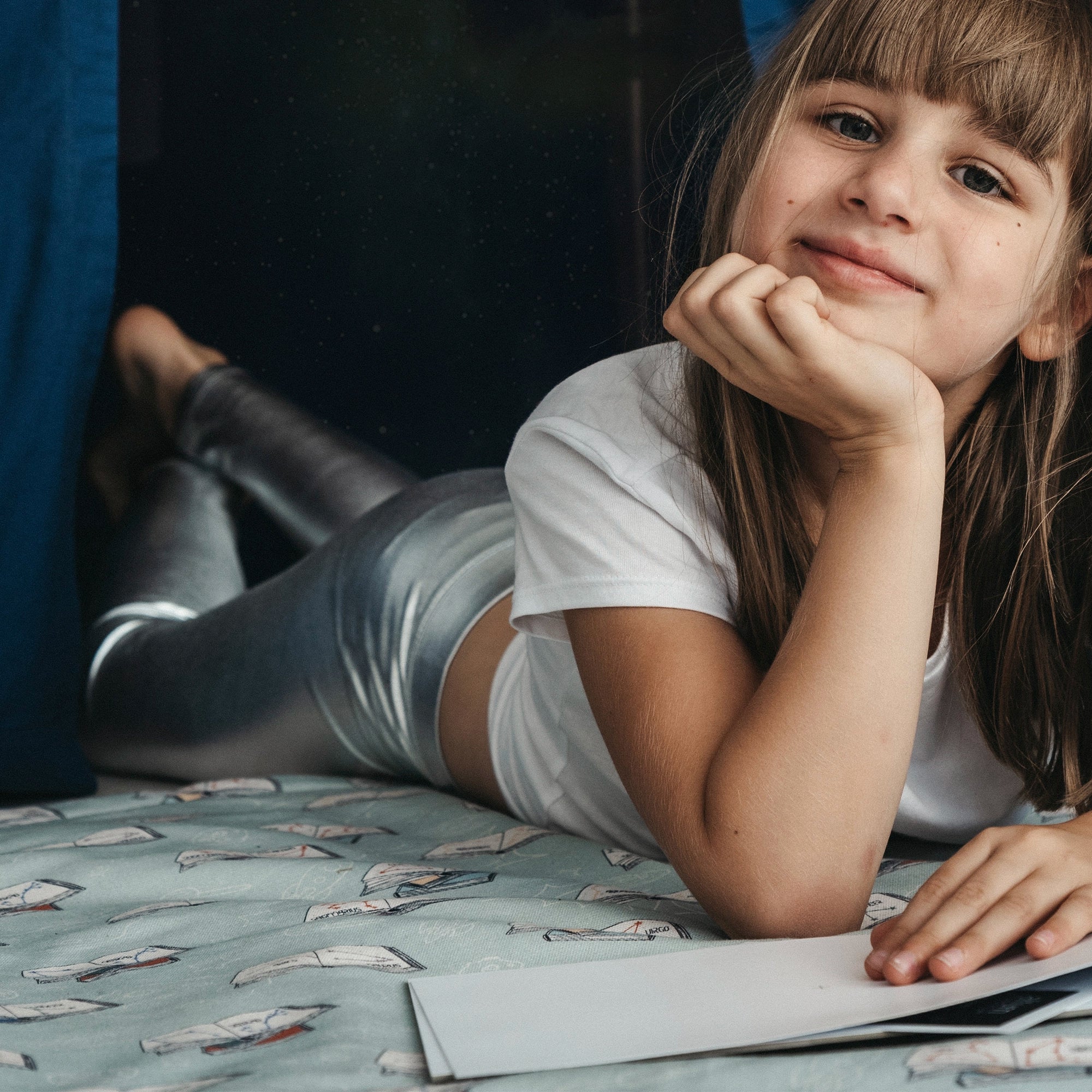 Kind entspannt auf der Fundertable Spielmatte im Lern- und Weltraumdesign – weich, gemütlich und ideal für ruhige Spiel- und Lernmomente unter dem Tisch mitten im Familienalltag