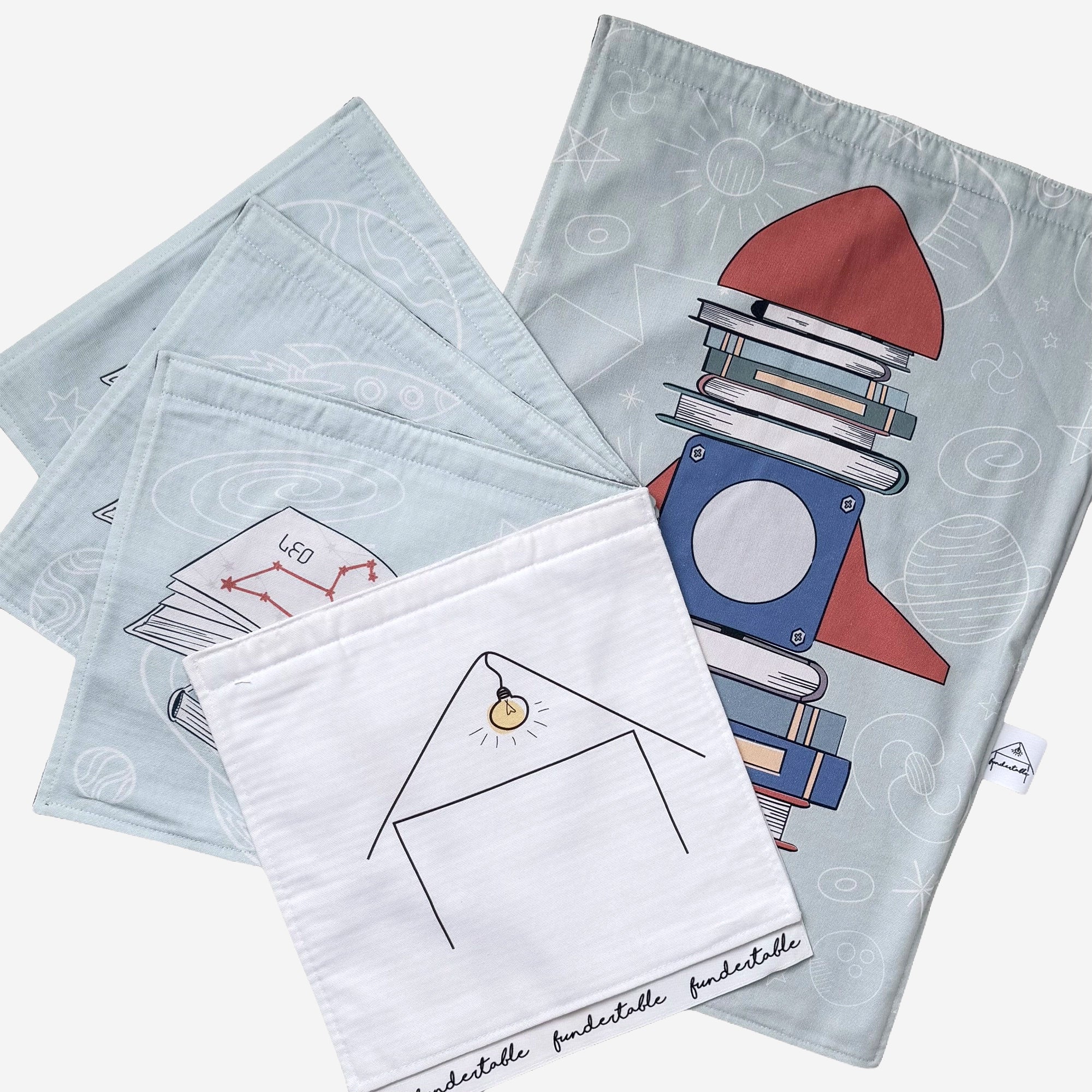 Fundertable Spielset mit Weltraum-Motiv, Rakete aus Büchern, Sternbildern und minimalistischem Haus in sanften Blautönen
