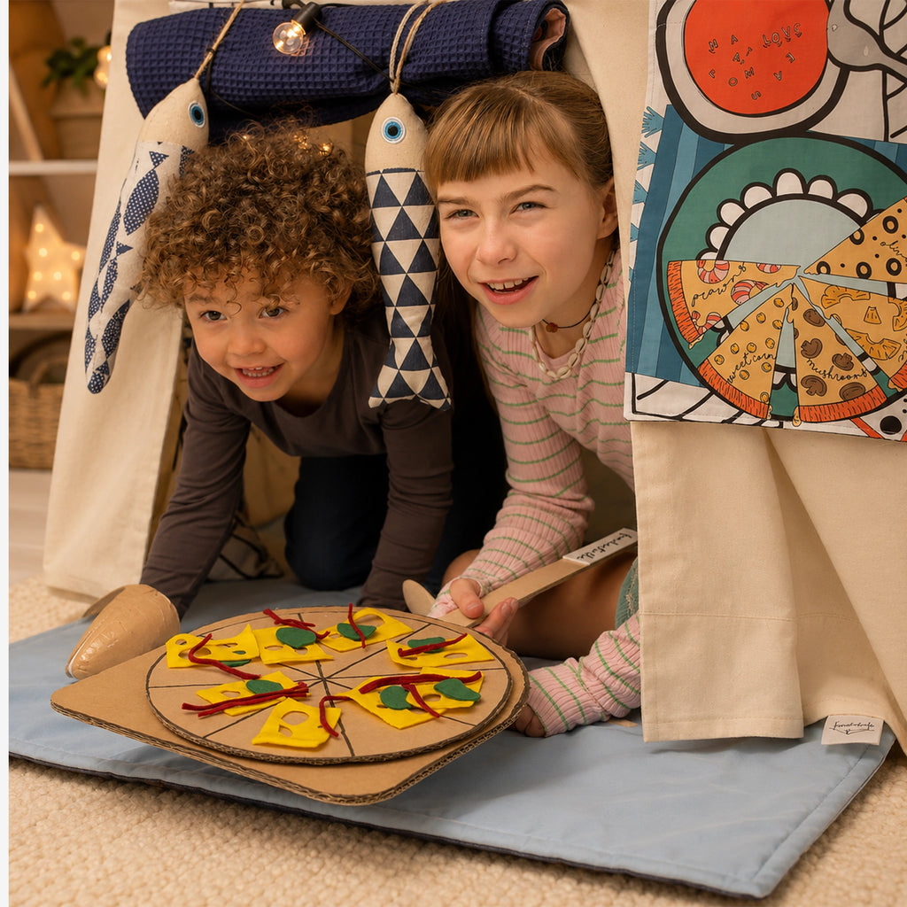Zwei Kinder spielen in einer Fundertable Base mit Spielmatte und Funderchef-Themenklappe. Sie servieren eine selbstgebastelte Pizza aus Karton.