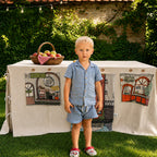 Fundertable Funderville mit Bäckerei- und Tierladen-Fenstern im Garten. Die textile Spielwelt unter dem Tisch schafft Raum für kreatives Rollenspiel, Fantasie und gemeinsame Familienmomente drinnen und draußen.