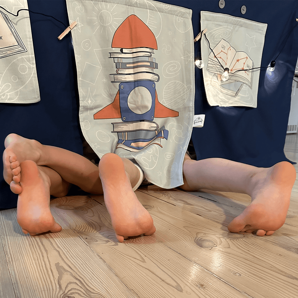 Children playing under a table tent with Fundertable interchangeable window panels in a space theme